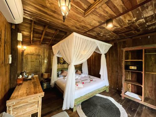 a bedroom with a bed with a canopy at Sekumpul Bali Hidden Space in Singaraja