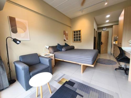 a bedroom with a bed and a chair and a desk at Stylish Studio Condo on the Beach in Ban Pak Khlong Phe