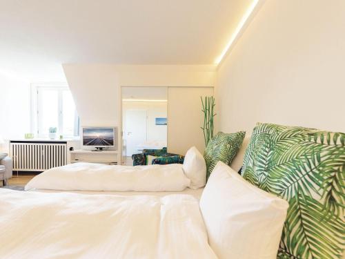 a bedroom with a white bed and a couch at Kliffsand-68 in Kampen