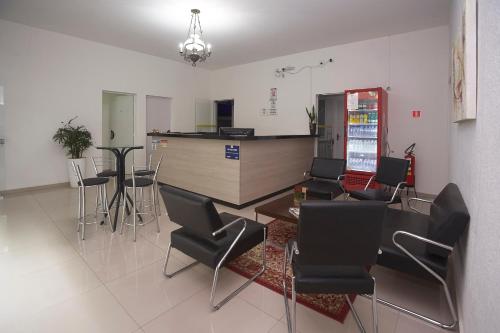 a room with chairs and a table and a kitchen at Hotel São João in Piracicaba