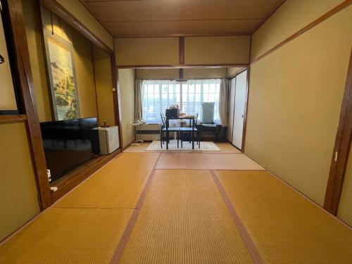a room with a table and a dining room at Hot Spring Inn Hyoutan in Kusatsu