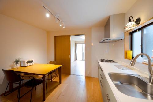 a kitchen with a table and a sink and a counter at SaiKa 隠れ家 in Saikamachi