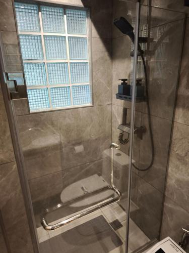 a shower with a glass door with a toilet at Stylish Studio Condo on the Beach in Ban Pak Khlong Phe