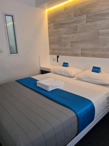 a bedroom with a bed with a blue blanket at Check Inn Hotel in Cape Town