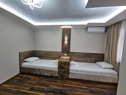 two beds in a room with a ceiling at Villa Diana Self check-in in Kiten