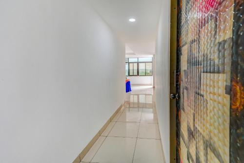 a hallway with a door and a wall of mosaic tiles at Hotel O Utrishree in Khandagiri