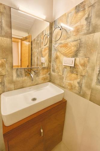 a bathroom with a sink and a mirror at Himalayan Fort Resort, Manali - A Riverside Retreat in Manāli