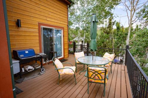 a patio with a table and chairs and an umbrella at Cozy 1BR Mountain View Studio with Fireplace &Deck in Fort Collins