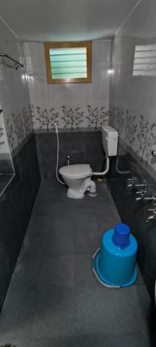 a small bathroom with a toilet and a window at Fantasy Homestay in Thiruchendur