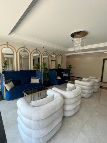 a living room with white furniture and blue couches at Best Home 38 Triumph in Alanya