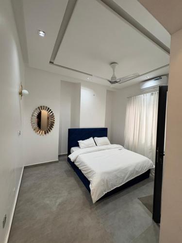 a bedroom with a white bed and a mirror at Appartement 2 chambres in Cotonou