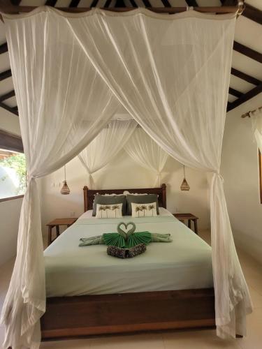 a bedroom with a bed with a canopy at Irmy's Village in Gili Islands
