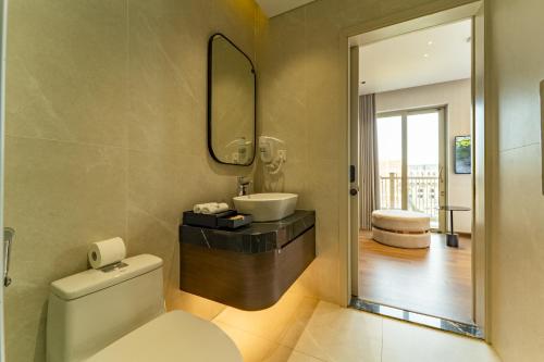 a bathroom with a toilet and a sink and a mirror at Villa 5 phòng ngủ cao cấp in Dong Hoi