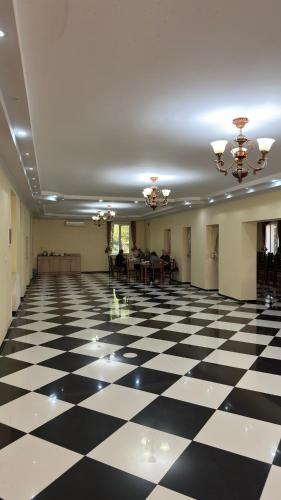 a large room with a black and white checkered floor at Hotel Giorgi in Tsqaltubo