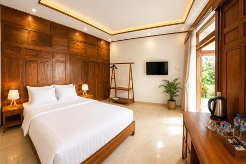 a bedroom with a large white bed and wooden walls at Villa Kebun Pala in Borobudur
