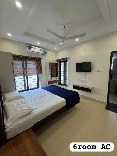 a bedroom with a bed and a flat screen tv at JSP OLIVE NEST villa in Yelagiri