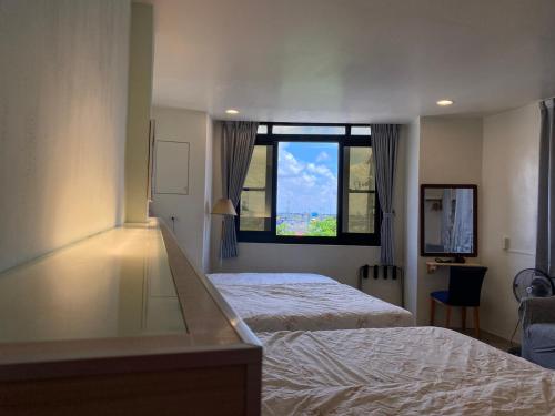 a bedroom with a bed and a large window at 東石民宿 湛藍海寓 Azure Seaside House in Dongshi