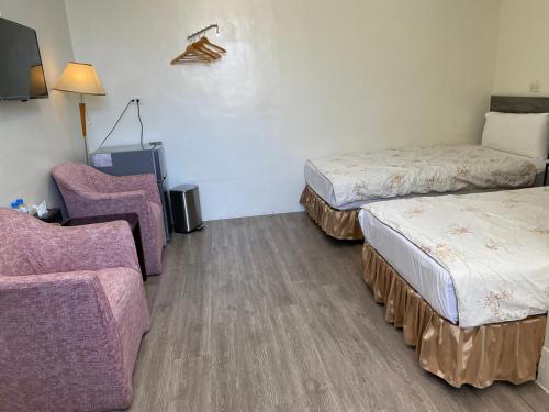 a hotel room with two beds and a chair at 東石民宿 湛藍海寓 Azure Seaside House in Dongshi