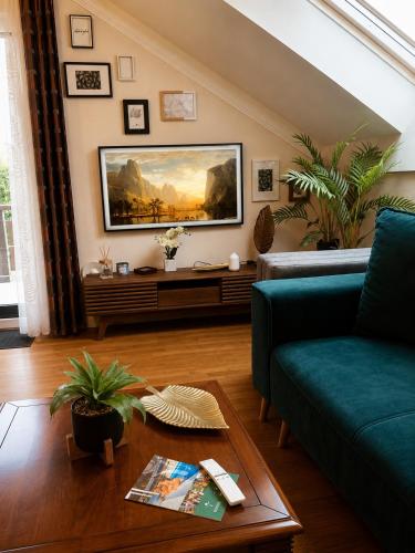 a living room with a green couch and a painting on the wall at Birdland Apartman in Bük