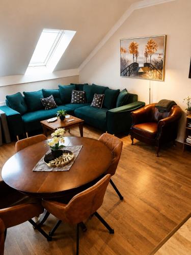 a living room with a green couch and a table at Birdland Apartman in Bük