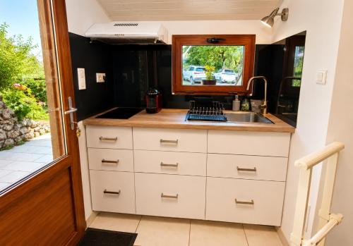 a small kitchen with a sink and a window at Chez Rose-Laure in Grandviala