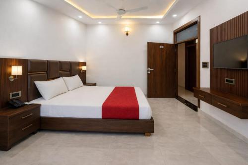 a bedroom with a large bed and a flat screen tv at Hotel Empress Gold in Agra