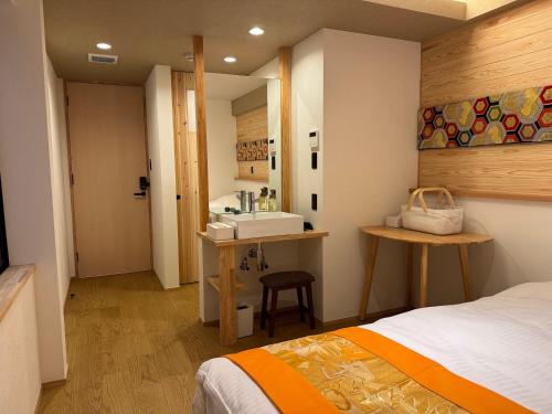 a bathroom with a bed and a sink in a room at Besso城前 in Himeji