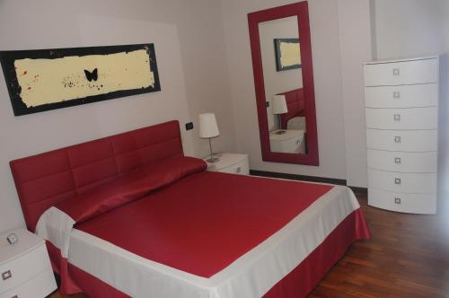 a bedroom with a red bed and a mirror at Residenza Segrate Centro Segrate in Segrate