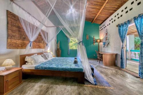 a bedroom with a bed with a mosquito net at Villa Lokobe in Hell-Ville