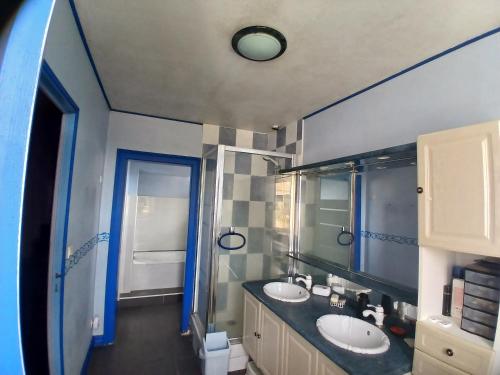 a bathroom with two sinks and a blue wall at Ferme Beauchêne in Laigné-en-Belin