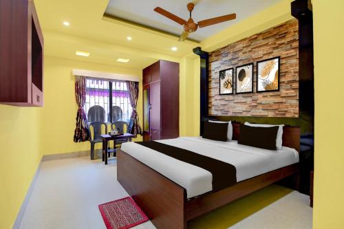 a bedroom with a bed and a brick wall at Super Hotel O Chittaranjan Railway Station Formerly Khalsa Lodge in Āsansol