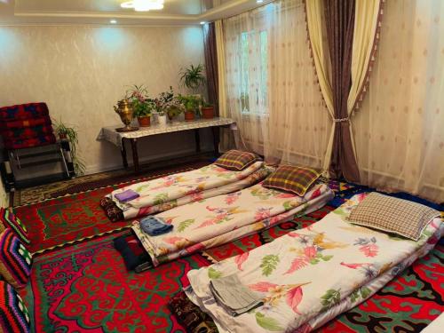 a room with three beds sitting on the floor at Oskon Guesthouse in Kyzart