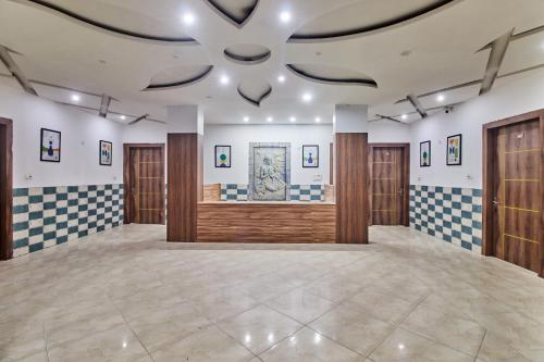 a large room with wooden doors and a ceiling at Treebo Chanakya Palm in Chhatikara