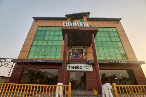 a building with a sign on the front of it at Treebo Chanakya Palm in Chhatikara