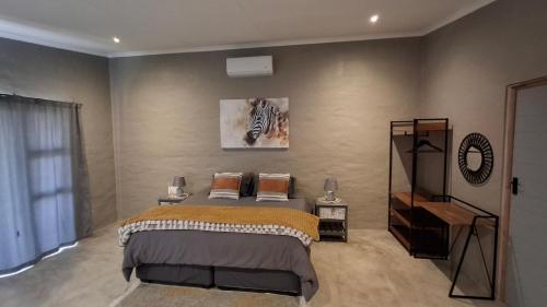 a bedroom with a bed and a picture of a zebra at GROOTVALLEI SELF CATERING Units in Mahikeng