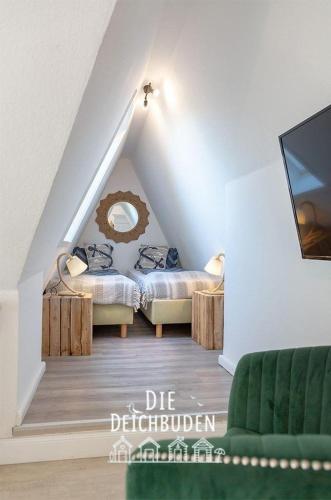 a attic room with two beds and a tv at Box-10 in Büsum