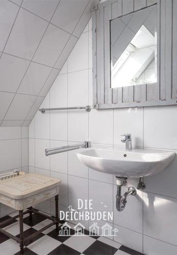 a white bathroom with a sink and a mirror at Box-10 in Büsum