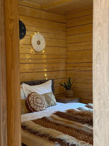 a bedroom with a bed in a wooden wall at Nice House in Maidan Village