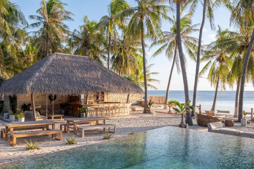 a resort with a swimming pool in front of the beach at Seed Resort in Nembrala