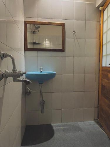 a bathroom with a blue sink and a mirror at BrightMoon_Homestay in Pondicherry