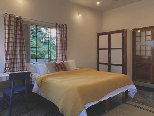 a bedroom with a bed and a table and a window at BrightMoon_Homestay in Pondicherry