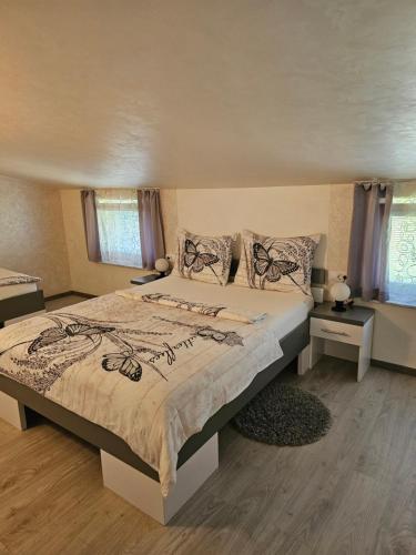 a bedroom with a large bed and two windows at Apartments Vesna in Bled