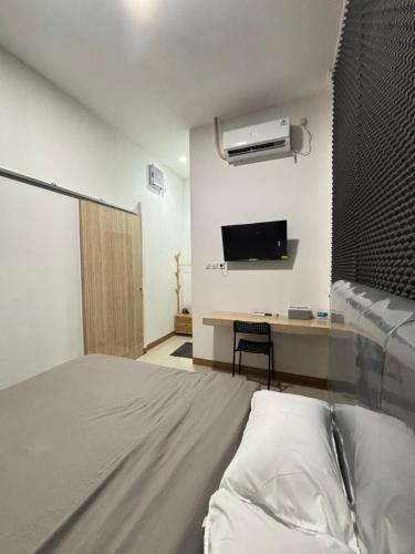 a bedroom with a bed and a desk with a tv at Lovisya Residence in Jakarta