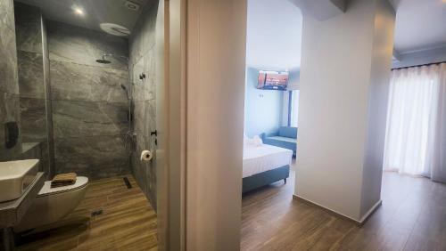 a bathroom with a sink and a toilet and a shower at Costa Mare Rooms in Paralia Katerinis