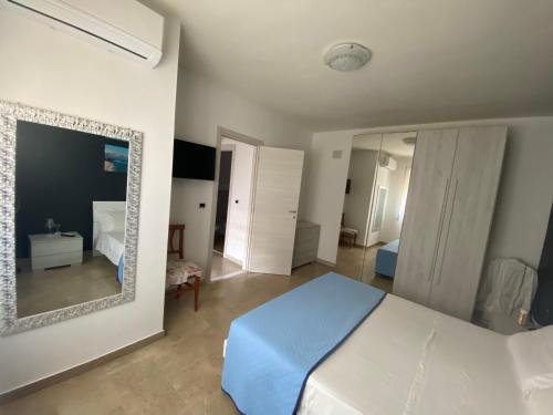 a bedroom with a white bed and a mirror at Near Sea in Monopoli