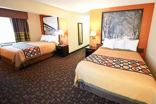 a hotel room with two beds and a mirror at Super 8 by Wyndham Clive IA in Clive