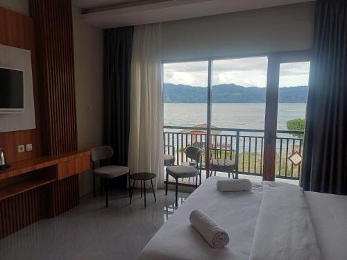 a hotel room with a bed and a view of the water at Lekjon Cottage in Tuktuk Siadong