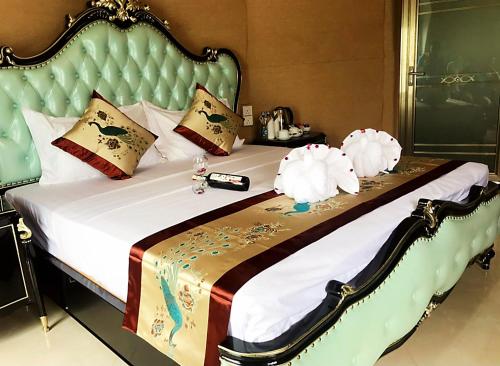 a bedroom with a large bed with a green headboard at Golden Ridge Sigiriya in Dambulla
