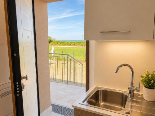 a kitchen with a sink and a view of a patio at Oasi Frontemare Appartamenti in Pineto