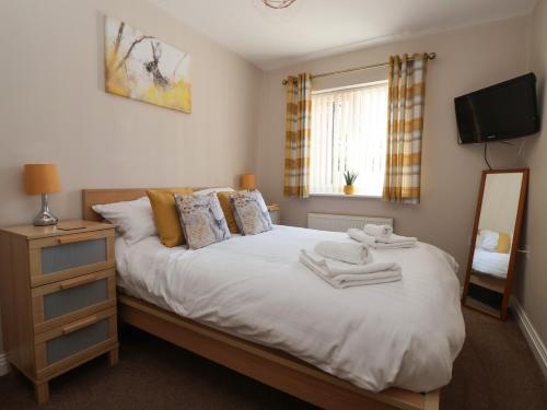 a bedroom with a bed with a mirror and a television at Church View in Hull